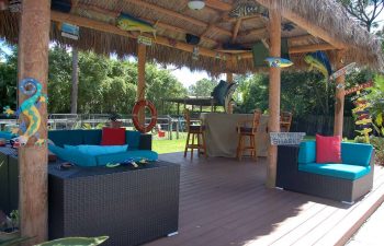 tiki hut with outdoor furniture in a landscaped garden