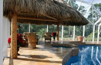 garden indoor swimming pool with a tiki hut and comfortable seats on a pool patio