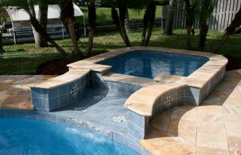backyard swimming pool with jacuzzi and paver patio after renovation