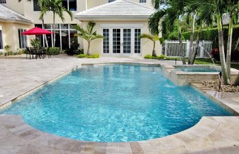 backyard swimming pool with jacuzzi and paver patio after renovation