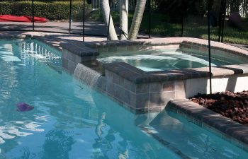 fenced backyard swimming pool with brick paver patio before renovation