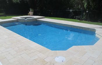 backyard swimming pool with jacuzzi and pool deck after renovation