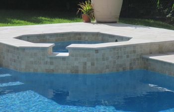 backyard swimming pool with jacuzzi and pool deck after renovation