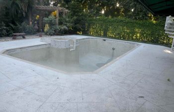 backyard swimming pool with jacuzzi and pool deck under renovation