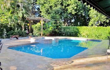 backyard swimming pool with jacuzzi and pool deck after renovation