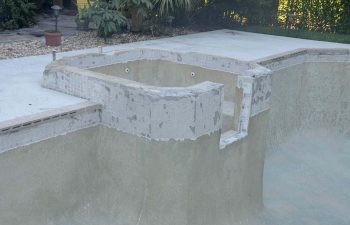 backyard swimming pool with jacuzzi and pool deck under renovation