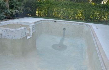 backyard swimming pool with jacuzzi and pool deck under renovation