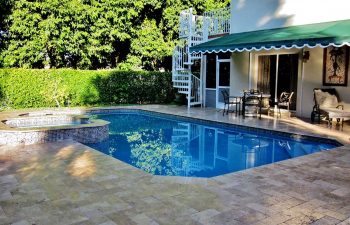 backyard swimming pool with jacuzzi and pool deck after renovation