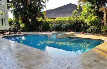 backyard swimming pool with jacuzzi and pool deck after renovation