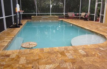 glass enclosed swimming pool with Travertine deck after renovation