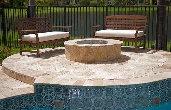 backyard swimming pool patio with a fire pit and seats around it