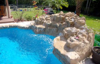 backyard swimming pool with a hardscape waterfall