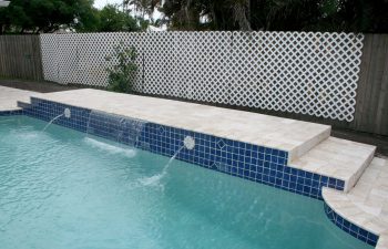 backyard swimming pool with decorative tiles and waterfalls