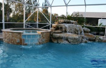 outdoor spa pools with a hardscape waterfall on the pool edge