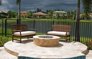 backyard swimming pool patio with a fire pit and seats around it