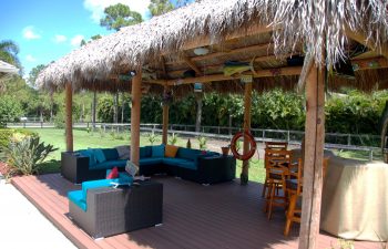 tiki hut with outdoor furniture in a landscaped garden