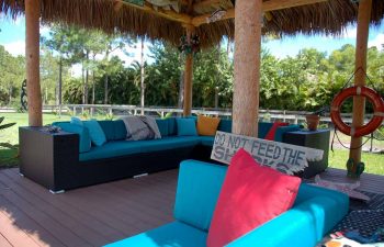 tiki hut with outdoor furniture in a landscaped garden