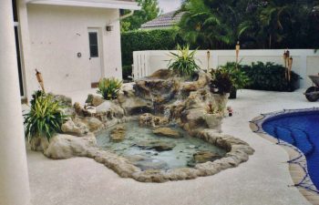 hardscape waterfall on a backyard pool deck