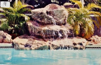 backyard swimming pool with a hardscape waterfall