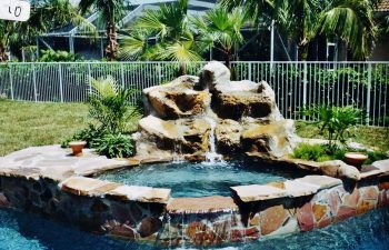 backyard spa pool with a hardscape waterfall