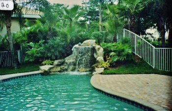 backyard swimming pool with a hardscape waterfall