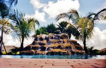 hardscape waterfall by an outdoor swimming pool