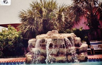 backyard swimming pool with a hardscape waterfall