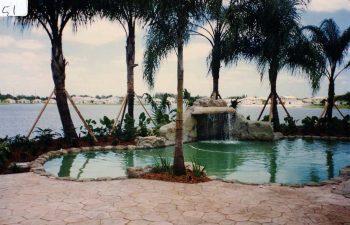 backyard in-ground swimming pool with a hardscape waterfall