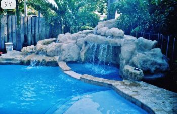 backyard swimming pool with a hardscape waterfall