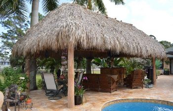 tiki hut with garden furniture by an outdoor spa pool