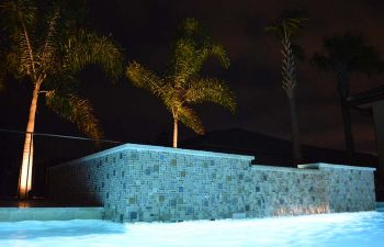 night view of a bakyard spa pool with waterfall