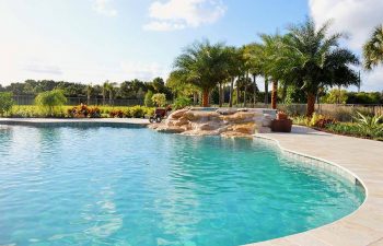 backyard spa pools with a hardscape waterfall formed between jacuzzi and pool