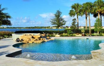 backyard spa pools with a hardscape waterfall and built-in fountains