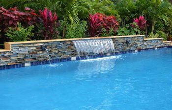 backyard pool waterfall coming out a stone brick wall