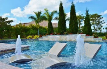 backyard swimming pool with built-in sunbeds and water features