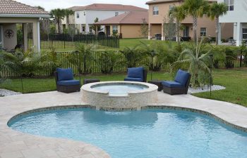 backyard swimming pool with jacuzzi and garden rattan furniture on a deck