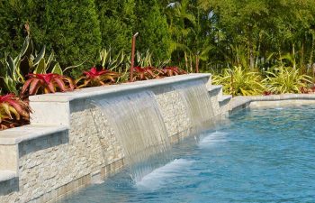 backyard swimming pool with a waterfall