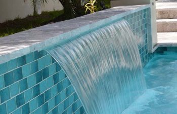 backyard swimming pool with a waterfall