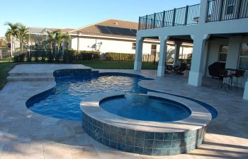 backyard swimming pool with jacuzzi and paver deck