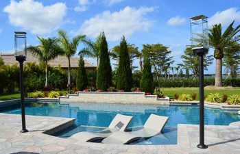 modern backyard swimming pool with built-in sunbeds and flagstone deck