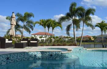 backyard swimming pool with light blue water color and jacuzzi