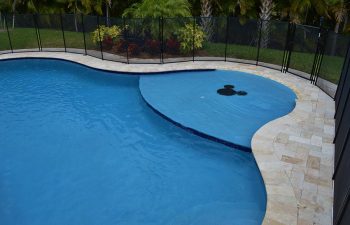 backyard swimming pool with paver deck and security fencing