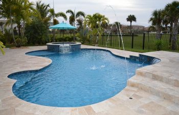 backyard swimming pool with water features and Travertine deck