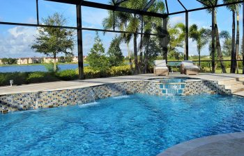 glass enclosed swimming pool with jacuzzi and waterfalls