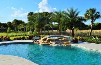 backyard swimming pool with a waterfall