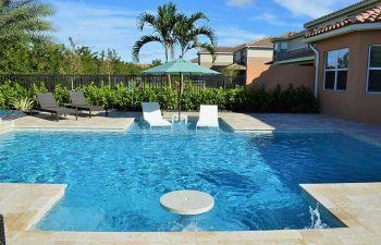 backyard swimming pool with sunbeds and sun umbrella