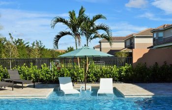 backyard swimming pool with sunbeds and sun umbrella