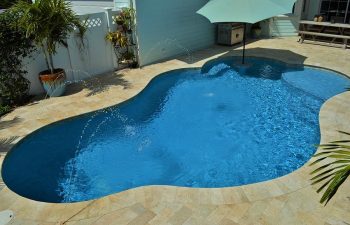 backyard swimming pool with fountains and Travertine deck