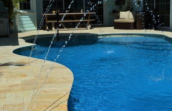 backyard swimming pool with fountains and Travertine deck