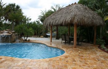 tiki hut with sunbeds on a backyard spa patio